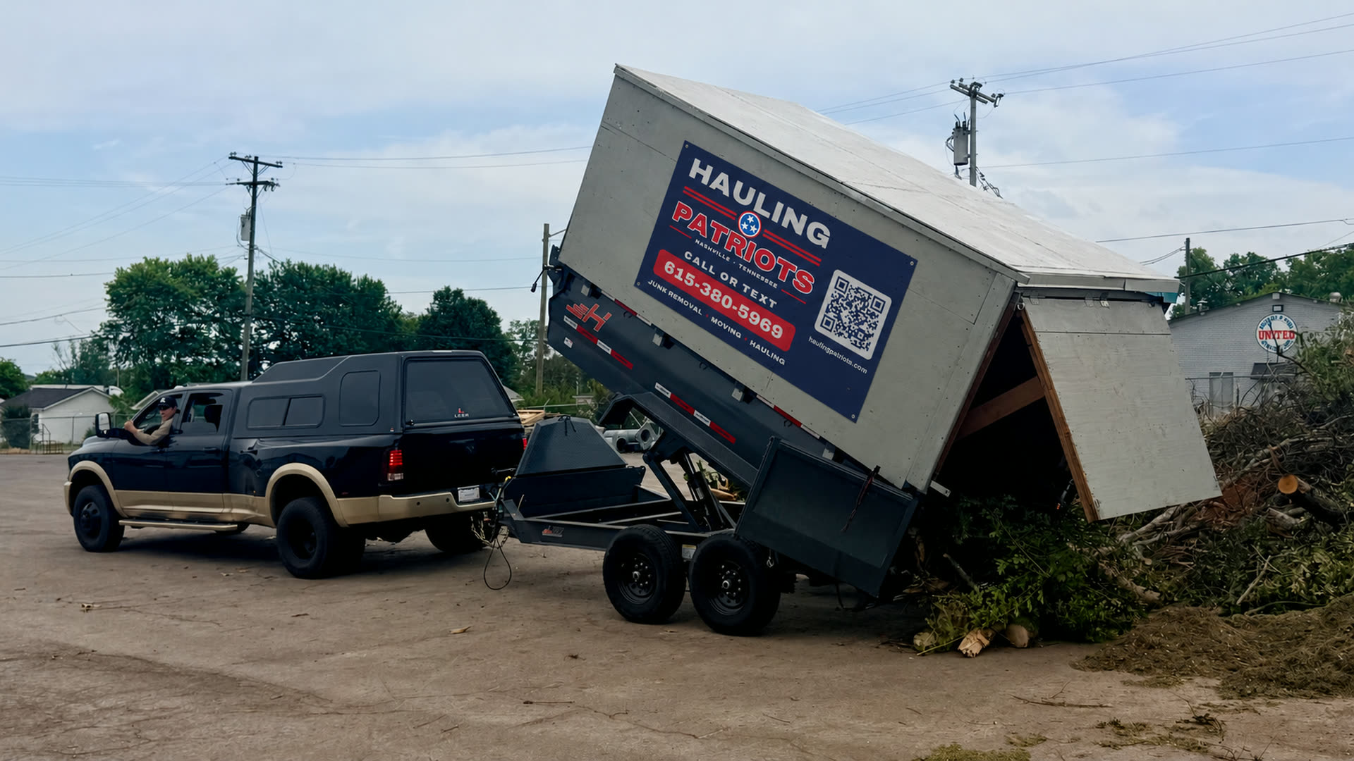 Hauling Patriots dump trailer raising a load of tree branches and yard debris at a Nashville job site