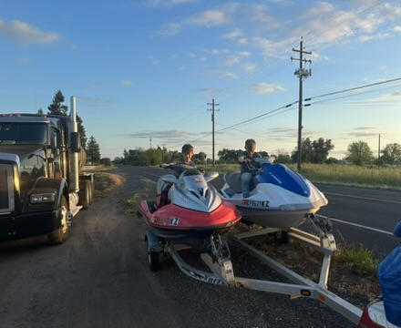 Hauling Patriots trailer loaded with jet skis at sunset in Middle Tennessee, staged for the next hauling job